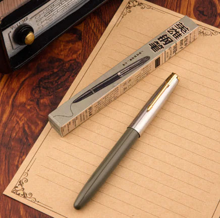 Pen with gold clip on a wooden surface next to its packaging