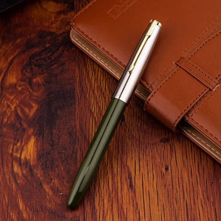Green pen with silver clip on a brown leather notebook on a wooden surface